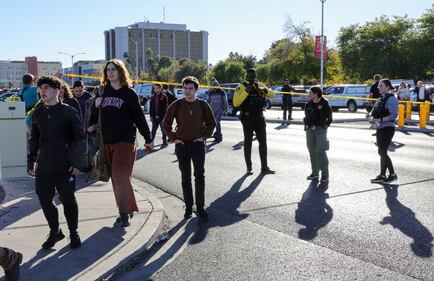 LAS VEGAS, NEVADA - DECEMBER 06: People cross Maryland Parkway as they are led off of the UNLV campus Maryland Parkway after a shooting on December 06, 2023 in Las Vegas, Nevada. According to Las Vegas Metro Police, a suspect is dead and multiple victims are reported after a shooting on the campus. (Photo by Ethan Miller/Getty Images)